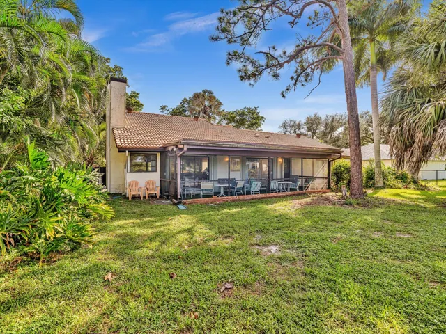 a view of a house with a yard and floor to ceiling window next to a yard