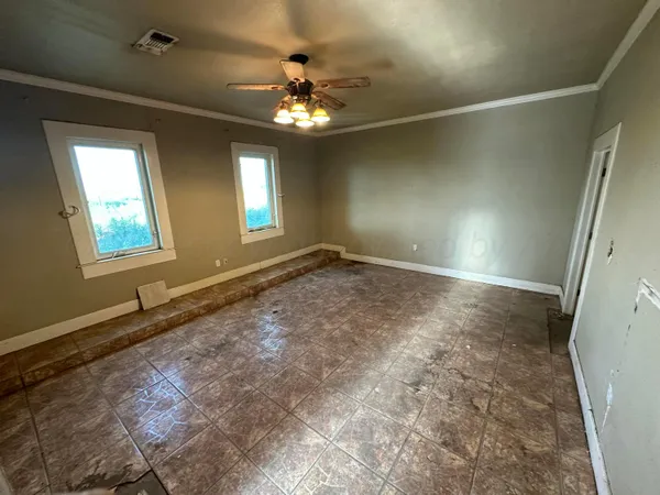 a view of an empty room with a chandelier fan