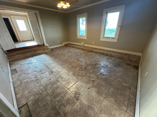 a view of an empty room with window and mirror