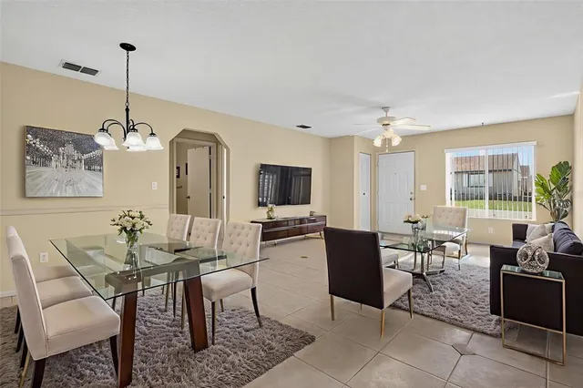 a living room with furniture a flat screen tv and a chandelier