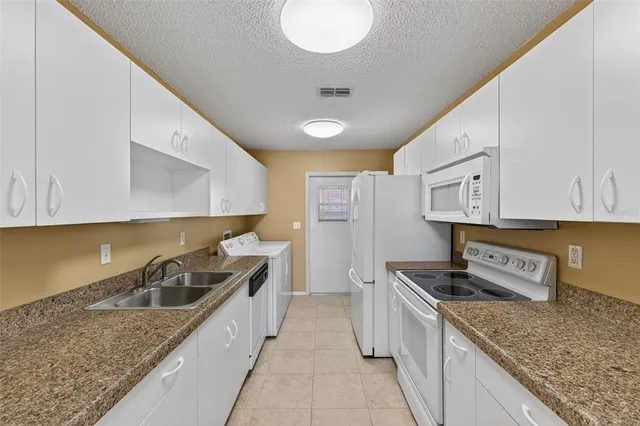 a kitchen with stainless steel appliances granite countertop a sink stove and cabinets