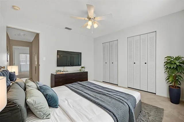 a bedroom with a bed and a potted plant