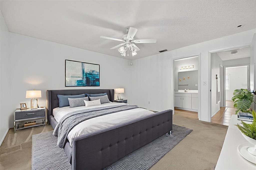 64 Winter Ridge Road, Unit 64 Winter Haven, FL 33881 - Photo 30 of 52 a spacious bedroom with a bed and a chandelier