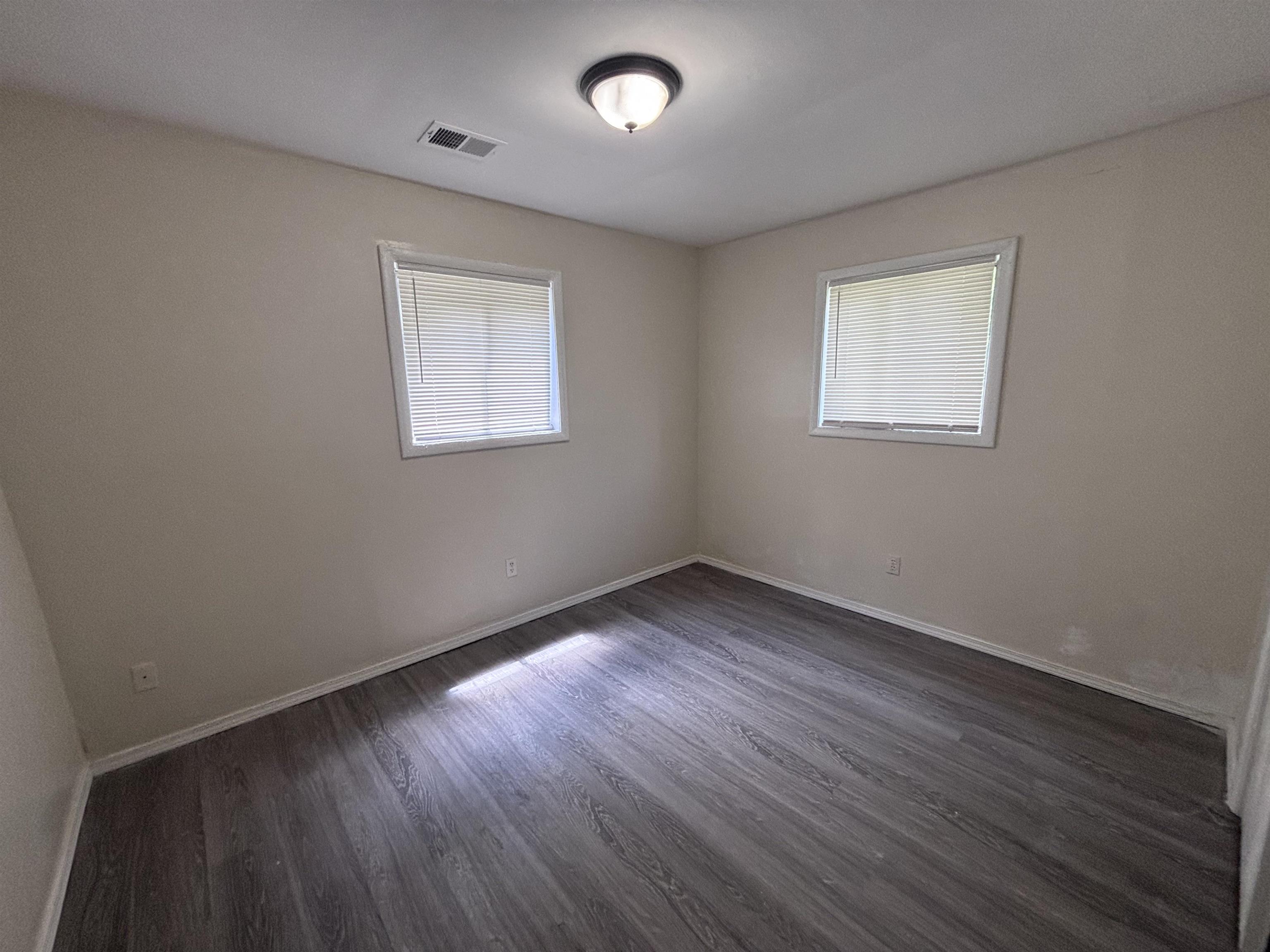 3589 Hawkins Mill Road Memphis, TN 38128 - Photo 8 of 9 a view of an empty room with wooden floor and a window