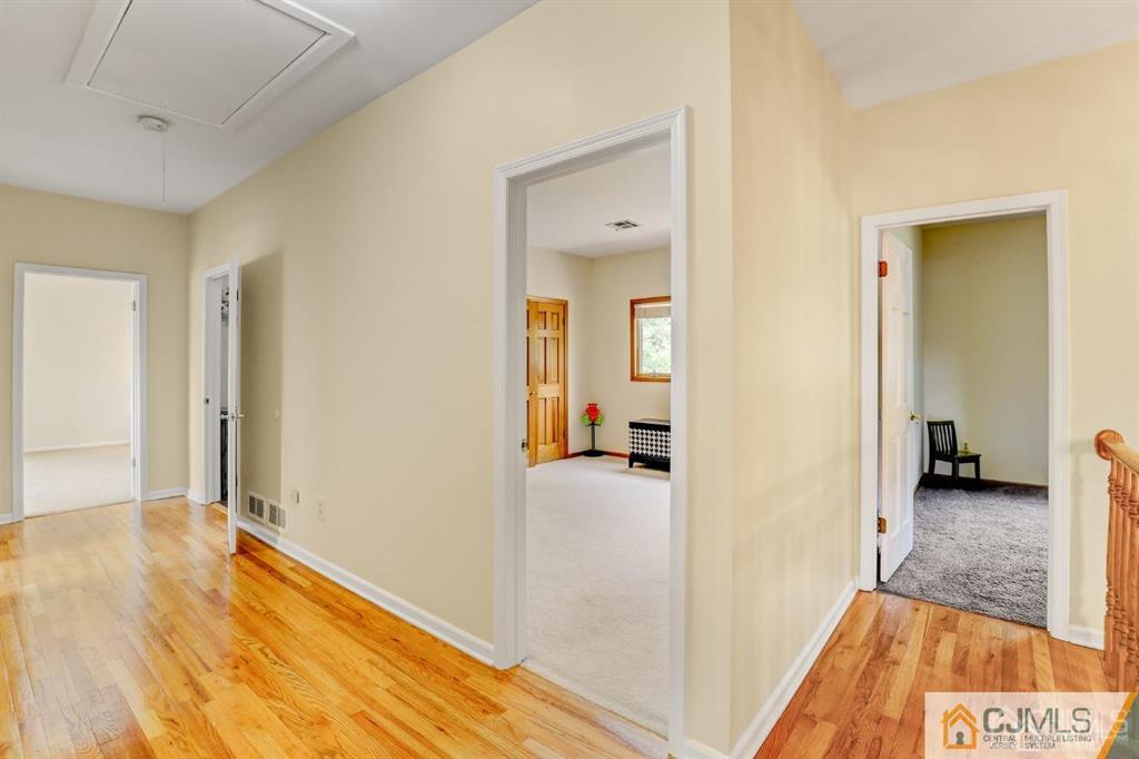 2 The Summit Holmdel, NJ 07733 - Photo 35 of 57 a view of a hallway with wooden floor and a living room
