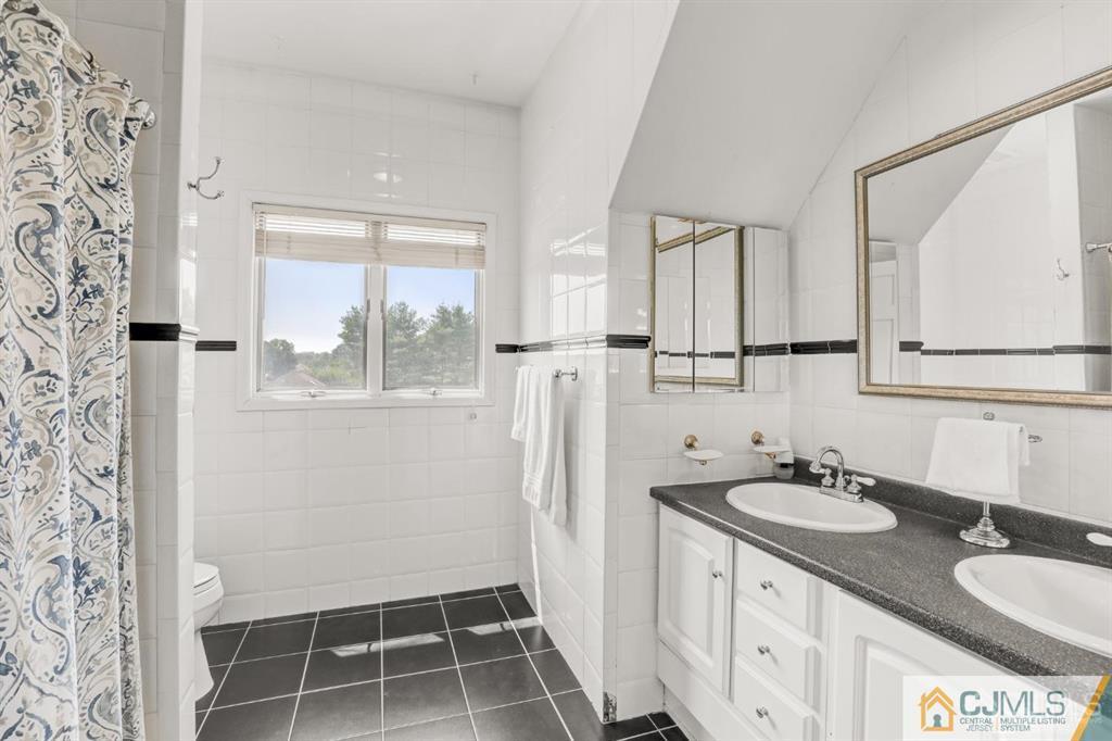 2 The Summit Holmdel, NJ 07733 - Photo 44 of 57 a bathroom with a granite countertop sink and a mirror