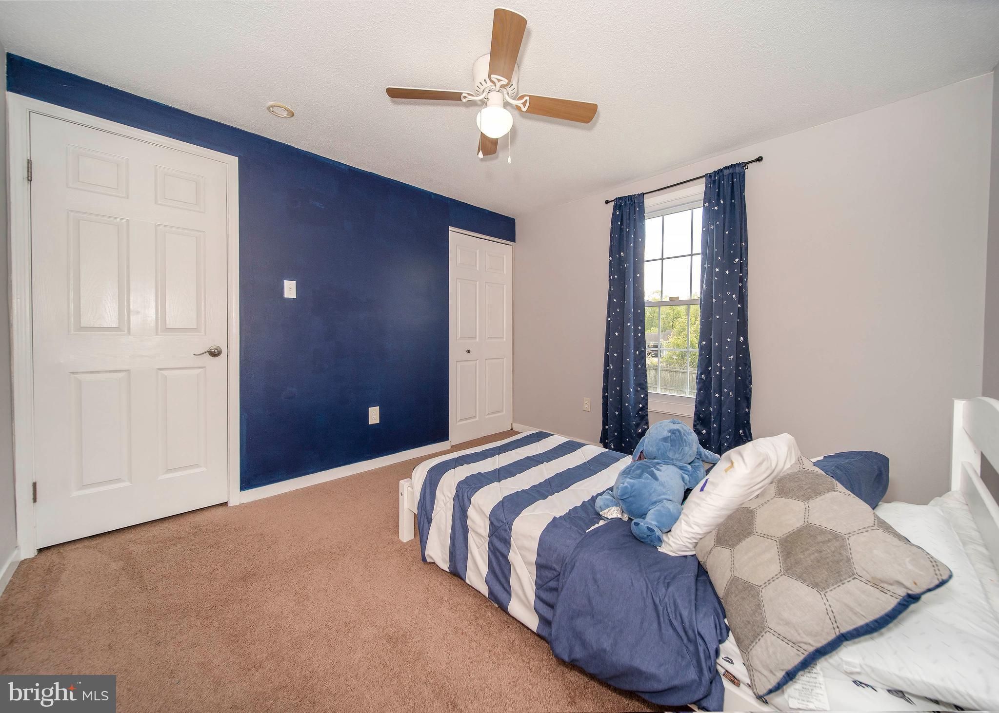 16 Leader Drive Newark, DE 19713 - Photo 16 of 28 a bedroom with a large bed and a chandelier