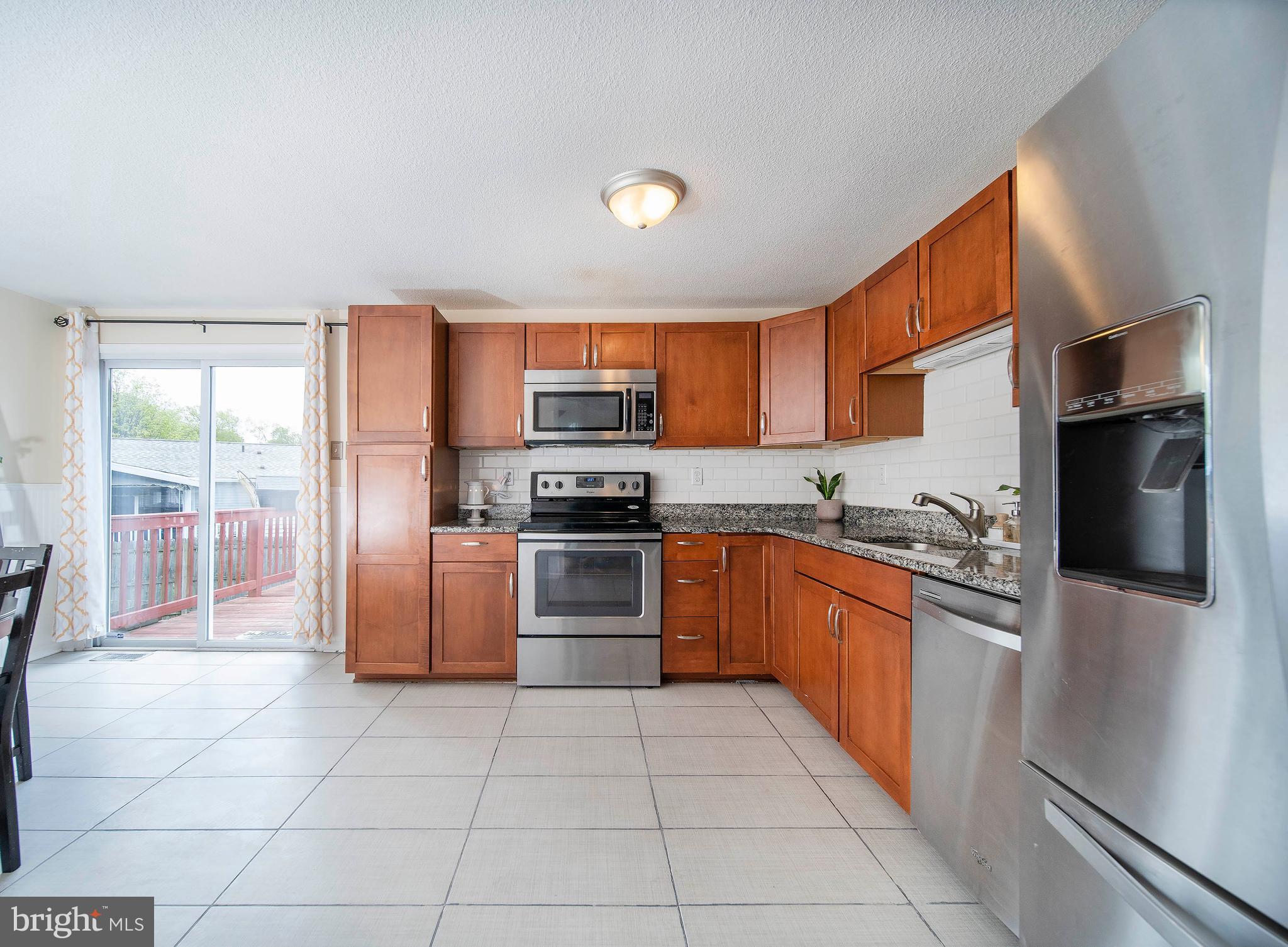 16 Leader Drive Newark, DE 19713 - Photo 7 of 28 a kitchen with stainless steel appliances granite countertop a refrigerator and a stove top oven