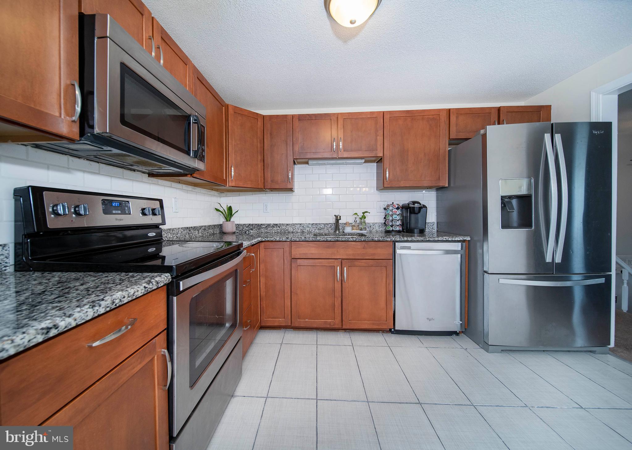 16 Leader Drive Newark, DE 19713 - Photo 8 of 28 a kitchen with stainless steel appliances granite countertop a refrigerator stove a sink and dishwasher
