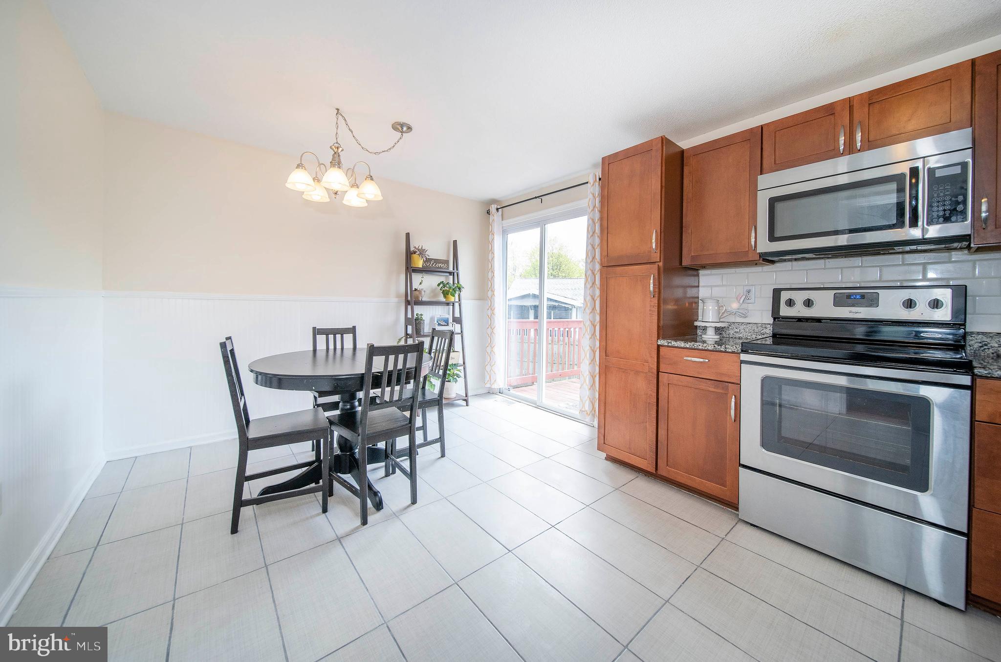16 Leader Drive Newark, DE 19713 - Photo 9 of 28 a kitchen with stainless steel appliances a stove a microwave a dining table and chairs
