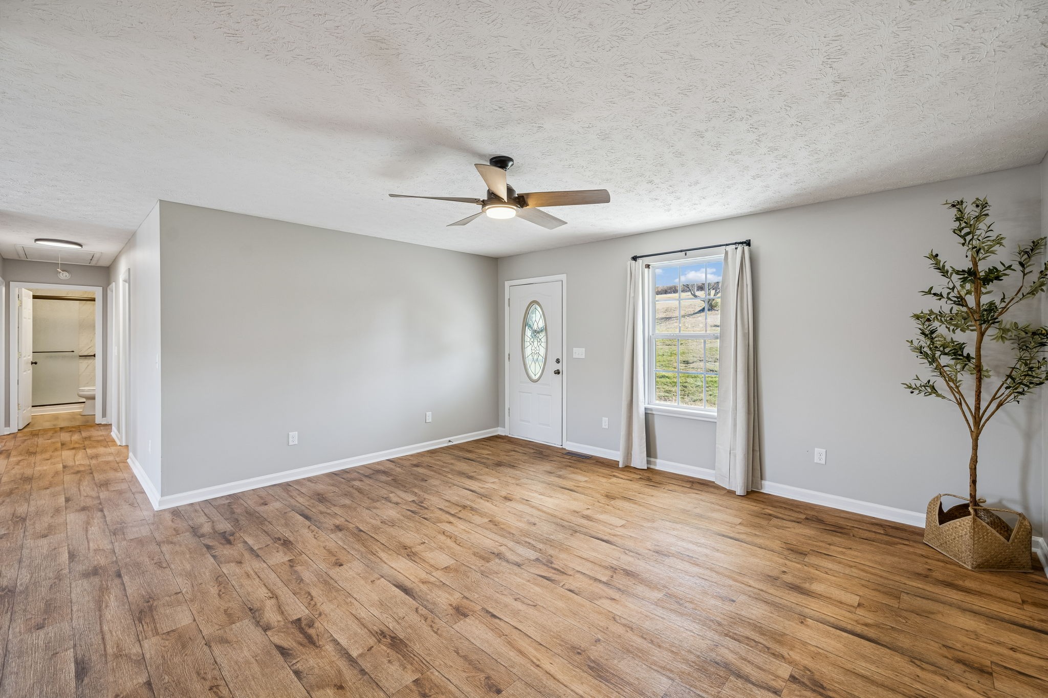 162 Pigeon Roost Road Brush Creek, TN 38547 - Photo 11 of 50 a view of an empty room with a window and wooden floor