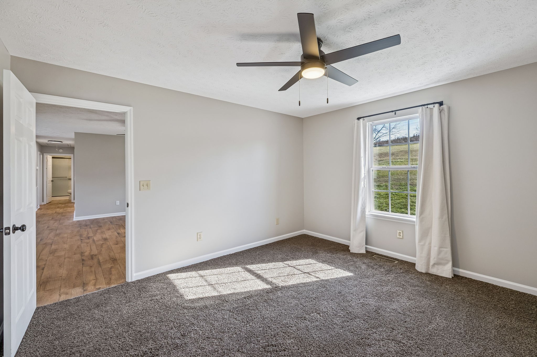 162 Pigeon Roost Road Brush Creek, TN 38547 - Photo 23 of 50 an empty room with a ceiling fan and windows