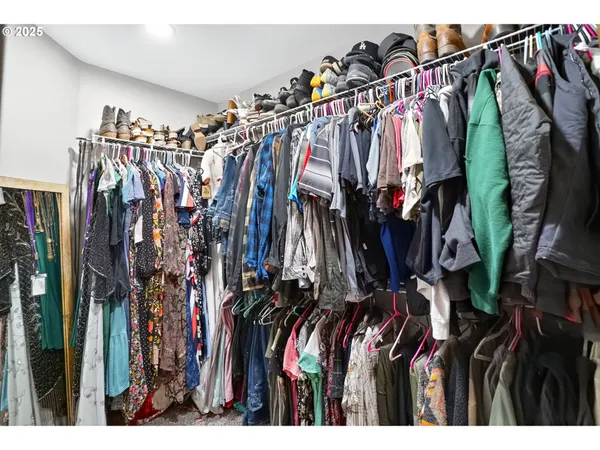 a view of walk in closet with clothes