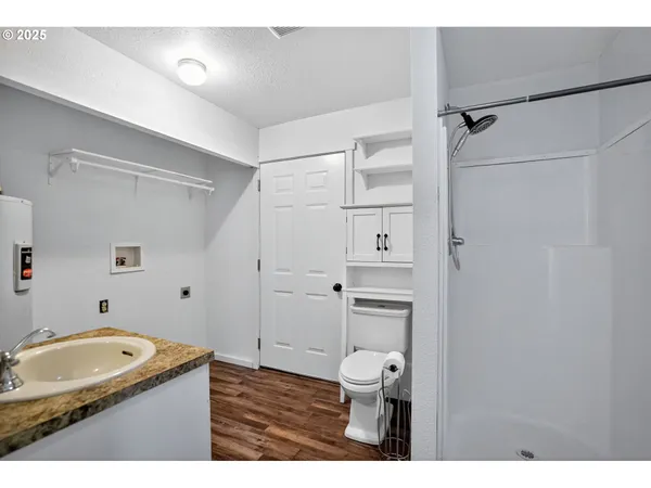 a bathroom with a granite countertop sink toilet and shower