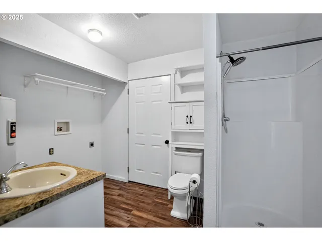 a bathroom with a granite countertop sink toilet and shower