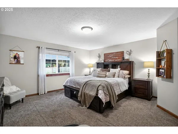 a spacious bedroom with a bed and wooden floor