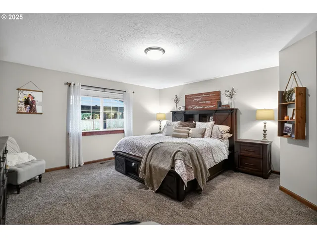 a spacious bedroom with a bed and wooden floor