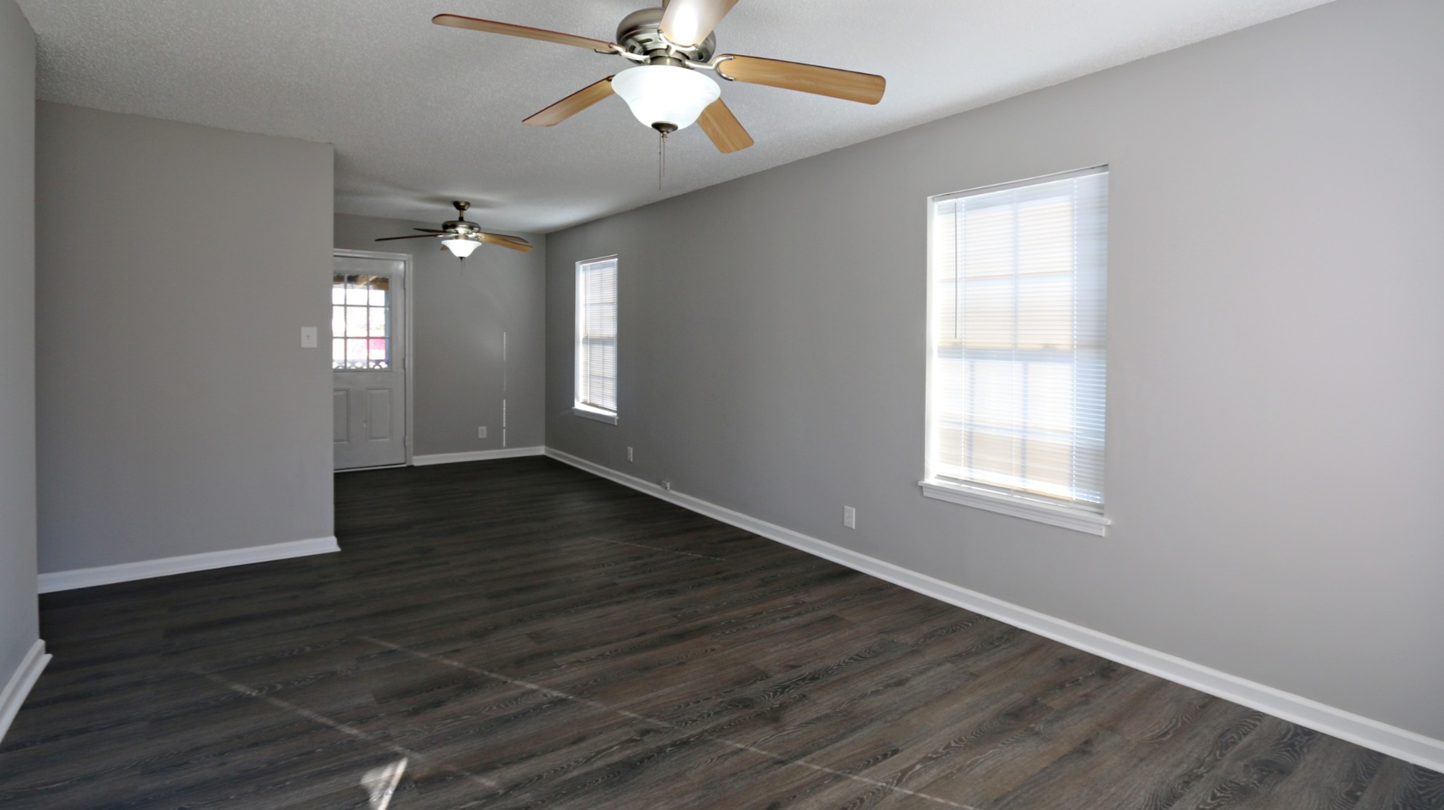 260 Hugh Hunter Road Oak Grove, KY 42262 - Photo 9 of 30 an empty room with wooden floor chandelier fan and windows