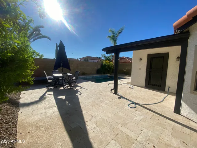 a view of a patio with table and chairs potted plants