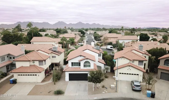 an aerial view of multiple houses with a city street