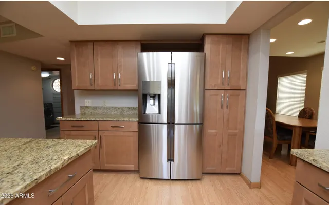 a kitchen with a refrigerator a microwave oven and a sink with wooden floor