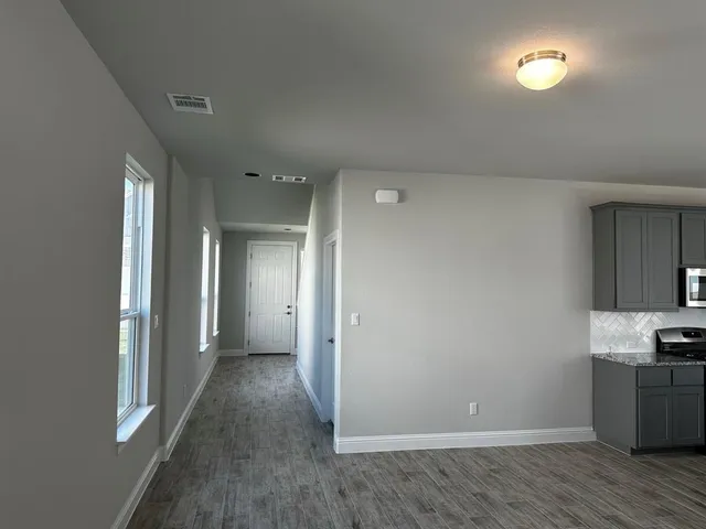 a view of a kitchen with wooden floor and a space