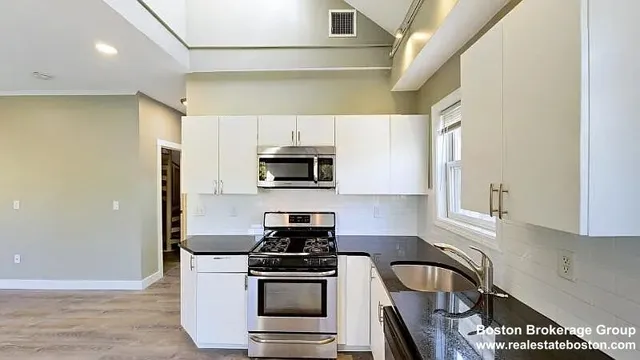 a kitchen with stainless steel appliances granite countertop a stove a microwave and a refrigerator