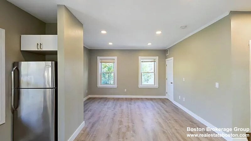 17 Ashley Street, Unit 3 Boston, MA 02130 - Photo 3 of 9 a view of a kitchen with a refrigerator and wooden floor