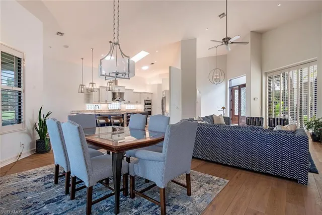 a dining room with furniture a chandelier and wooden floor