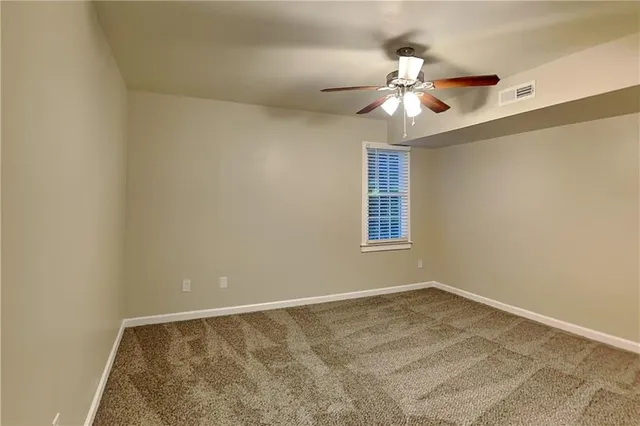 an empty room with a window and a ceiling fan