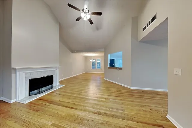 a view of empty room with wooden floor and fireplace