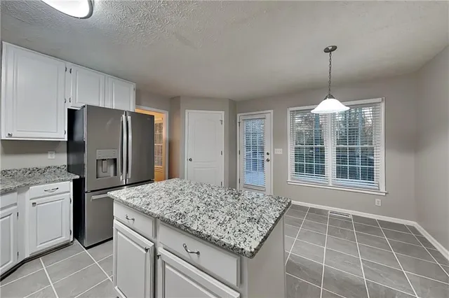 a kitchen with kitchen island granite countertop a stove a refrigerator island and a cabinets