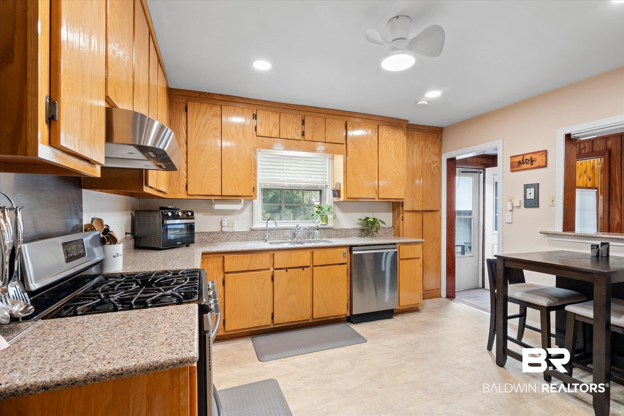 162 Bit And Spur Terrace Mobile, AL 36608 - Photo 5 of 29 Kitchen with light stone countertops, sink, ceiling fan, stainless steel appliances, and exhaust hood