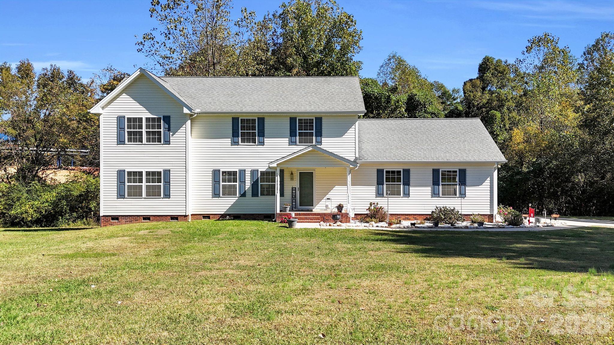 10425 Idlewild Road Matthews, NC 28105 - Photo 1 of 25 a front view of a house with a garden and trees
