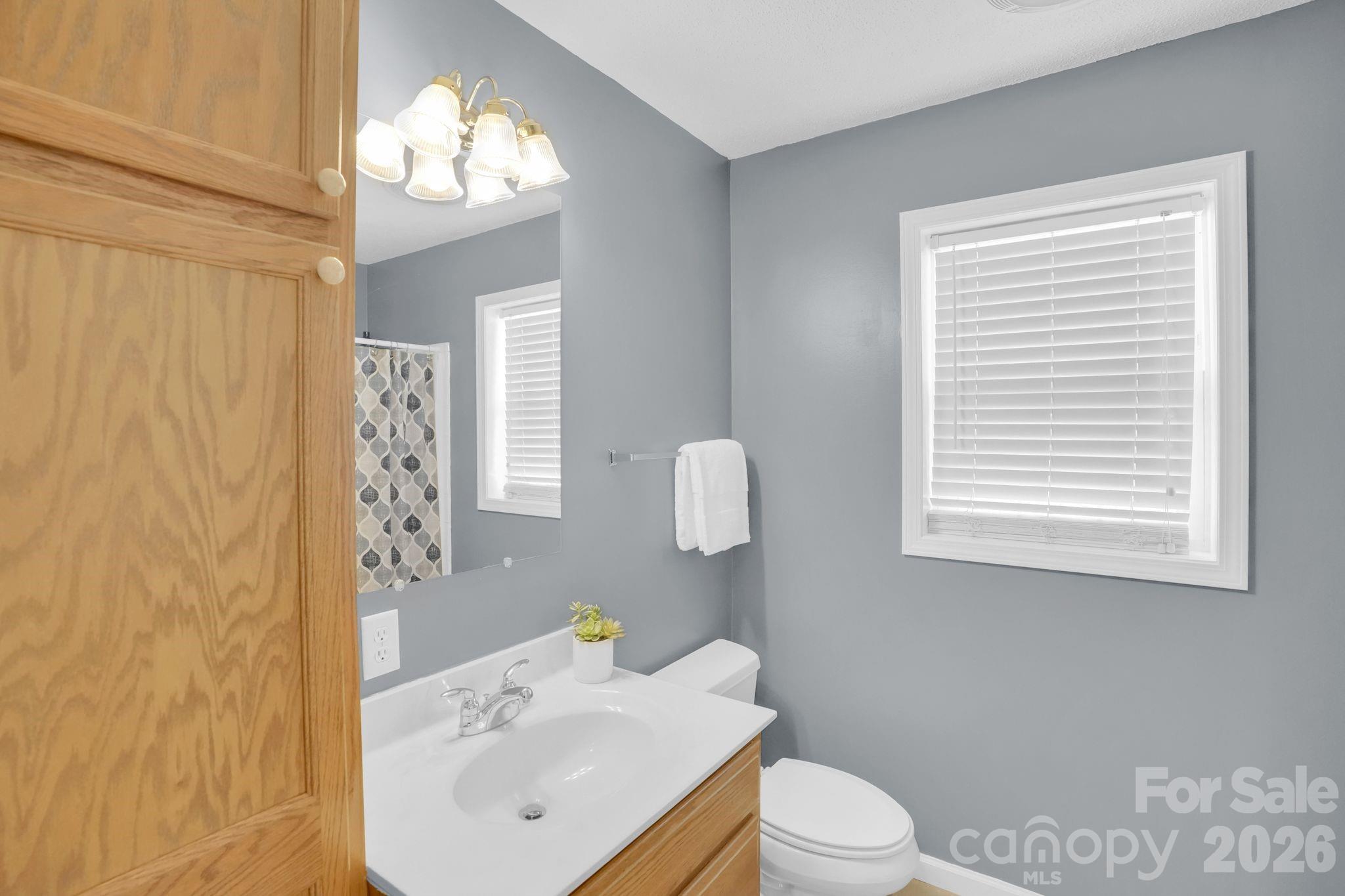 10425 Idlewild Road Matthews, NC 28105 - Photo 12 of 25 a bathroom with a sink a toilet and mirror