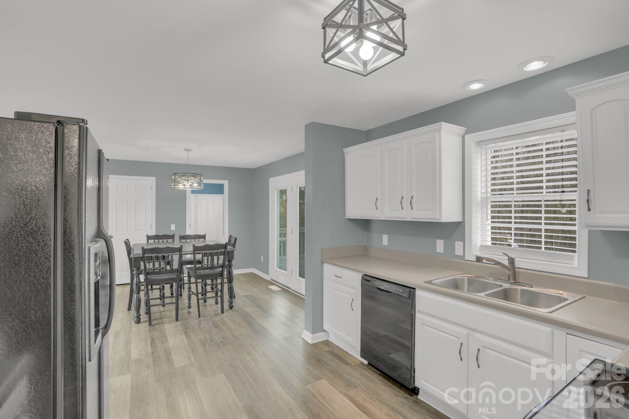 10425 Idlewild Road Matthews, NC 28105 - Photo 6 of 25 a kitchen with a table chairs microwave and cabinets
