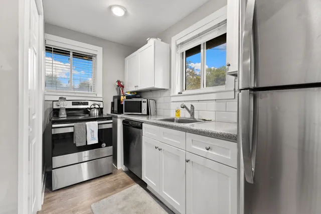 a kitchen with white cabinets and appliances