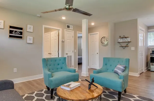 a living room with furniture and a wooden floor