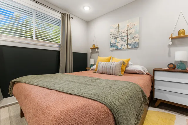 a bedroom with a bed and painting on the wall