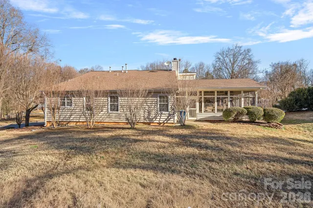a view of a large house with a big yard and large trees