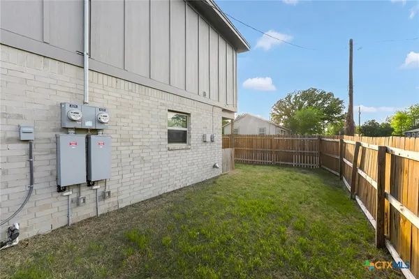 a view of backyard with wooden fence