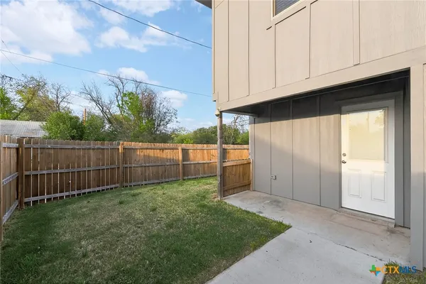 a view of a backyard with wooden fence
