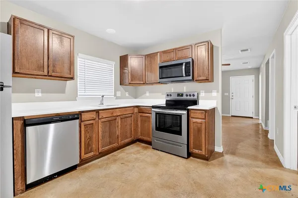 a kitchen with stainless steel appliances granite countertop a stove a sink and a microwave