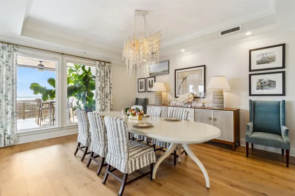a view of a dining room with furniture a chandelier and wooden floor