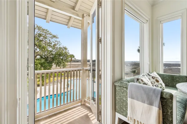 a white bed sitting in a bedroom next to a window