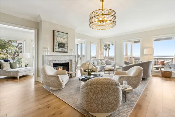 a living room with furniture a chandelier and a dining table