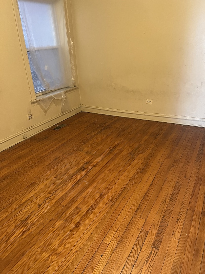 8010 South Evans Avenue, Unit 1 Chicago, IL 60619 - Photo 11 of 13 a view of an empty room with wooden floor and a window