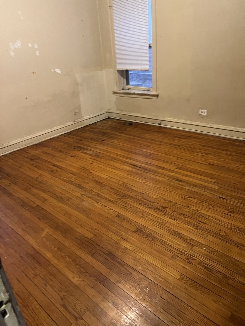 8010 South Evans Avenue, Unit 1 Chicago, IL 60619 - Photo 13 of 13 an empty room with wooden floor and windows