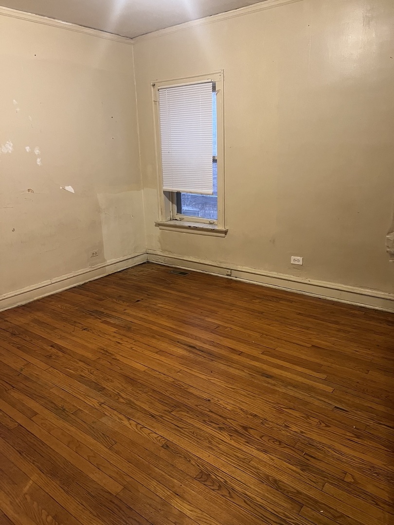 8010 South Evans Avenue, Unit 1 Chicago, IL 60619 - Photo 5 of 13 a view of an empty room with wooden floor and a window