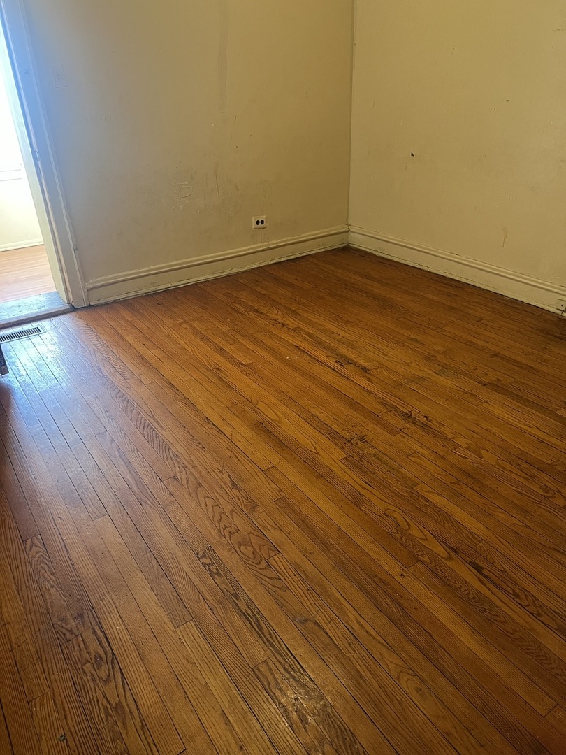 8010 South Evans Avenue, Unit 1 Chicago, IL 60619 - Photo 6 of 13 an empty room with wooden floor and windows